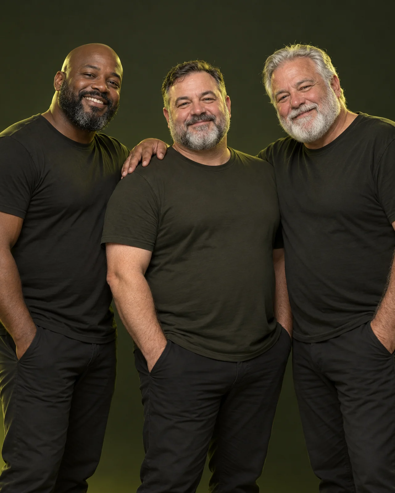 Three adult men sharing a friendly studio portrait